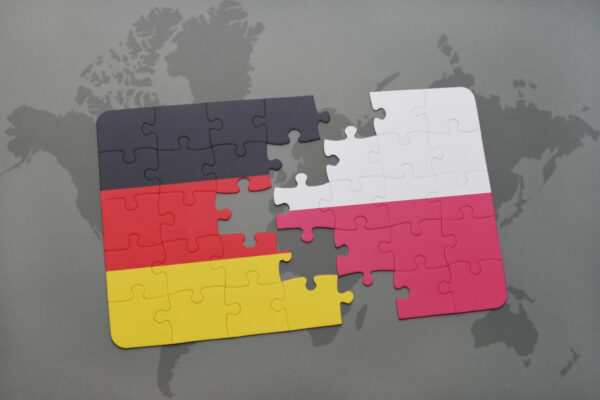 Puzzle w kolorach flag Niemiec i Polski, symbolizujące tłumaczenia z języka niemieckiego.