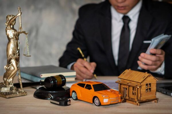 Mężczyzna w garniturze pracuje nad tłumaczeniem dokumentów samochodowych przy biurku.